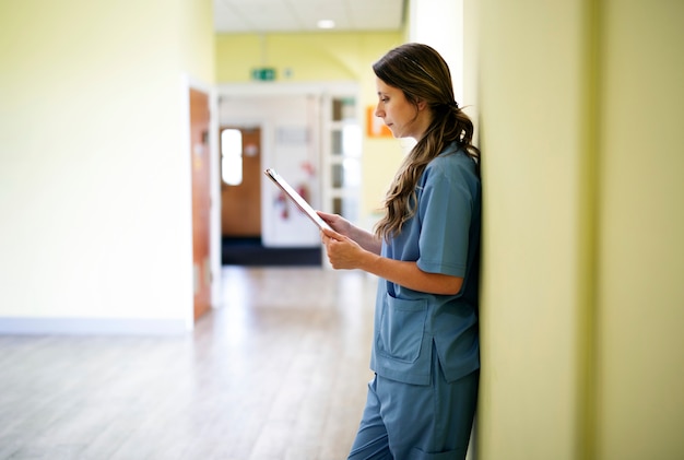 Infirmière lisant les dossiers médicaux dans le couloir