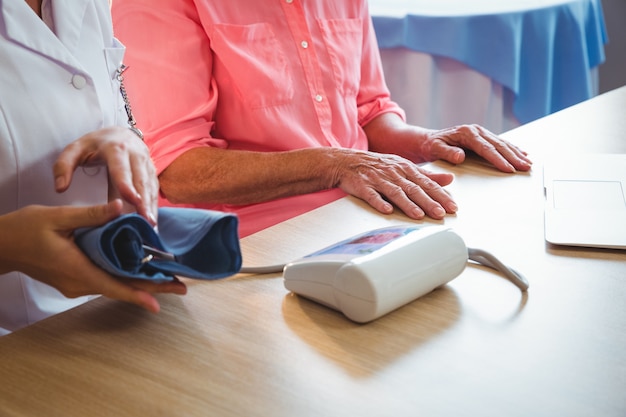 Infirmière mesurant la pression artérielle d'une femme âgée