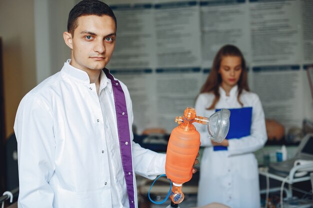 L'infirmière procède à la réanimation. Le médecin aide la femme à effectuer l'opération.