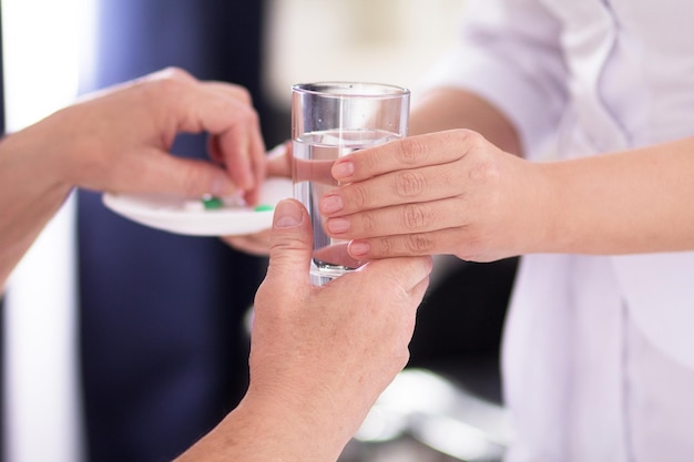 Infirmière remettant de l'eau à son patient