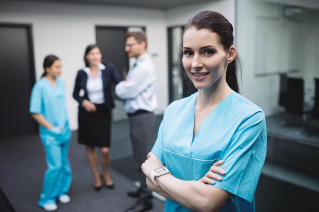 Infirmière souriante debout avec les bras croisés