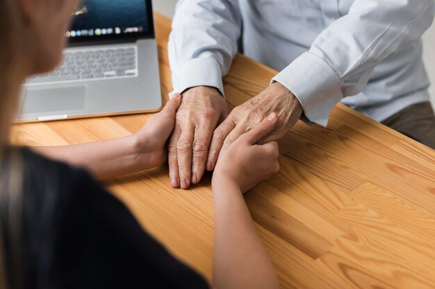 Infirmière tenant les mains de l'homme senior pour le soulagement