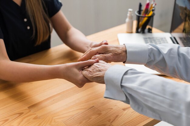 Infirmière tenant les mains de l'homme senior