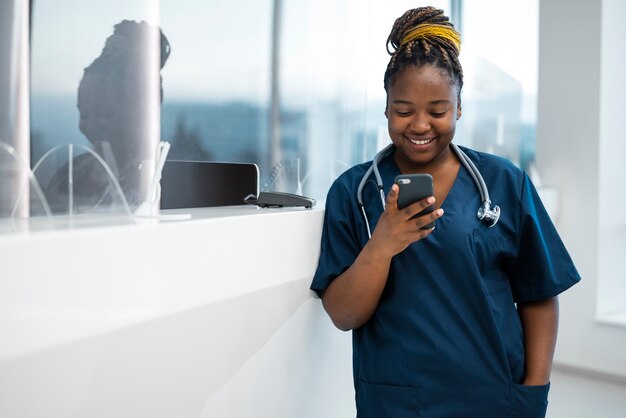 Infirmière vue de face tenant un smartphone