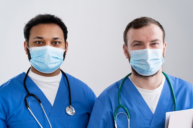 Infirmières à coup moyen portant des masques faciaux