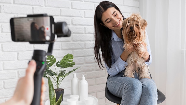 Photo gratuite influenceuse à la maison avec smartphone et animal de compagnie