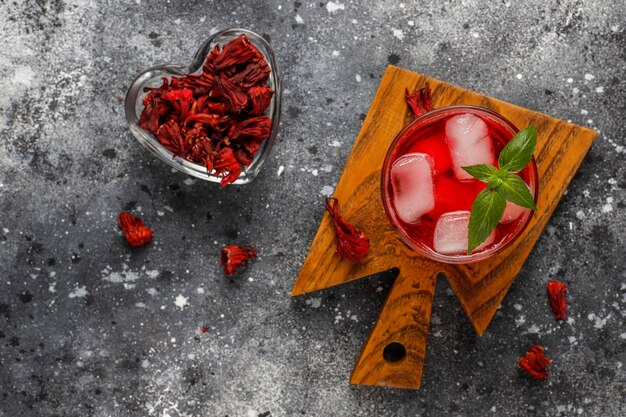 Infusion froide de thé d'hibiscus avec de la glace et des feuilles de basilic.