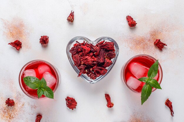 Infusion froide de thé d'hibiscus avec de la glace et des feuilles de basilic.