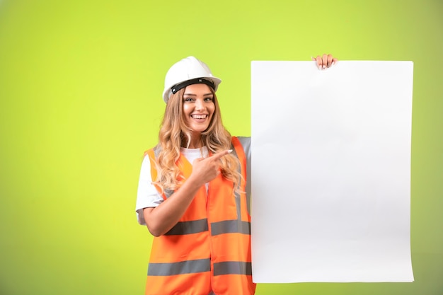 Ingénieur en casque blanc et équipement présentant le plan de construction.