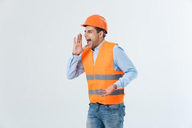 Ingénieur en colère avec une émotion de visage en colère criant à quelqu'un levant les deux mains, isolé sur fond blanc.