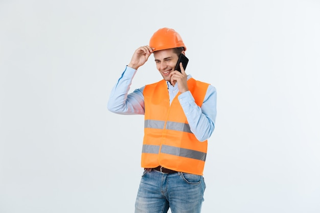 Ingénieur en construction souriant posant isolé sur fond gris.