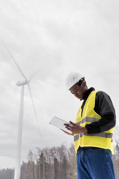 Ingénieur à coup moyen tenant une tablette à l'extérieur