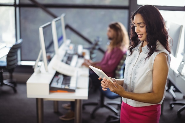 Ingénieur du son féminin en studio à l'aide de tablette numérique