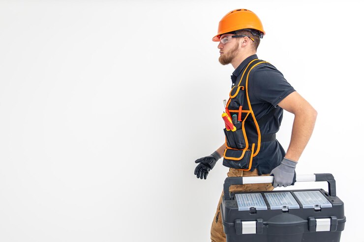 Photo gratuit ingénieur électricien de construction masculin en combinaison et casque tient une boîte à outils dans les mains espace pour le texte