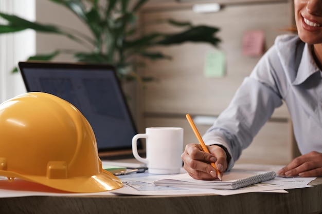 Photo gratuite ingénieur féminin écrivant des notes tout en travaillant sur un nouveau projet au bureau