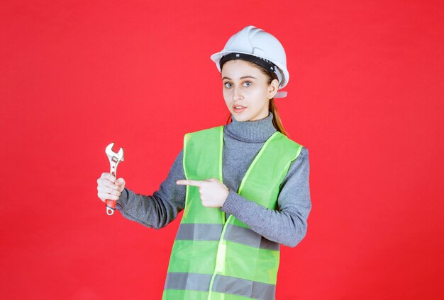 Ingénieur Femme Avec Casque Blanc Tenant Une Clé Métallique.