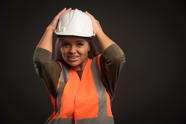 Ingénieur femme portant un casque et un équipement blanc.