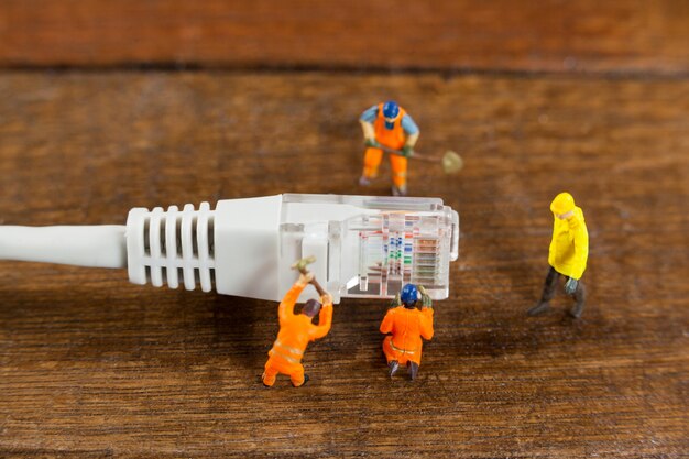 ingénieur miniature et les travailleurs travaillant avec câble lan