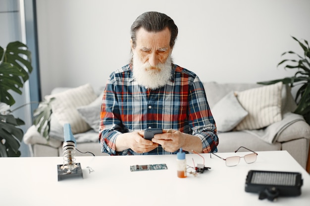 Ingénieur principal vérifier le téléphone après réparation. Reconnaissance des gadgets.