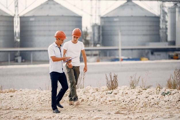 Ingénieurs en casques debout près de l'usine