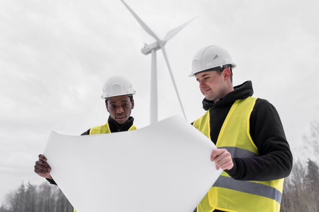 Ingénieurs en environnement à plan moyen tenant un plan