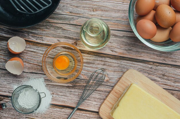 Ingrédient de cuisson: farine, œuf, lait et rouleau à pâtisserie, vue de dessus