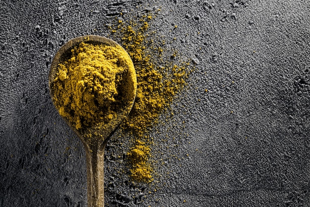 Photo gratuite ingrédients alimentaires aux épices cuillère en bois sur fond gris de table