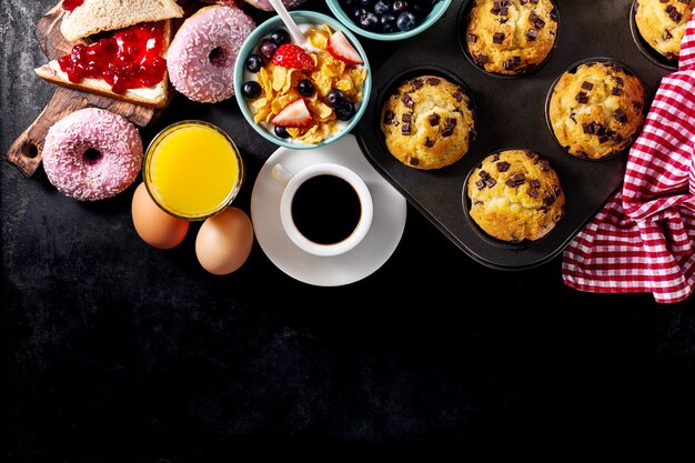 Des ingrédients alimentaires délicieux au petit-déjeuner frais sur fond noir sombre. Prêt à cuisiner. Concept de cuisson en nourriture saine à la maison.