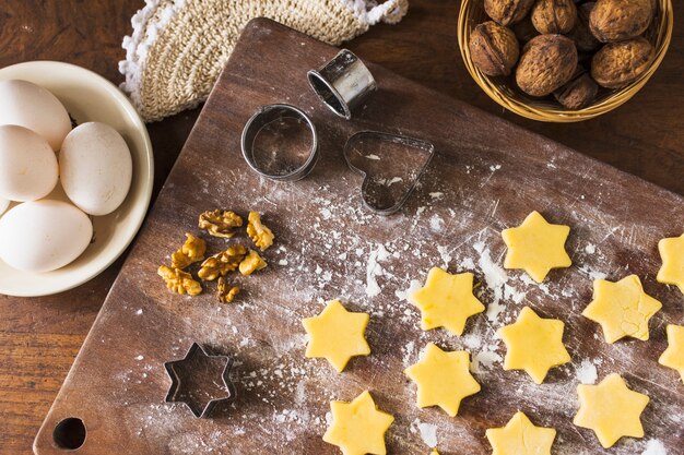 Ingrédients et emporte-pièces près des biscuits crus