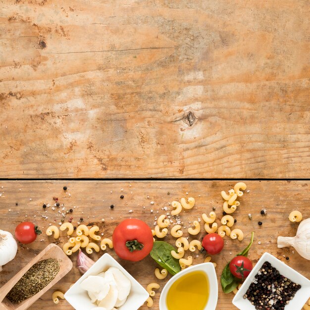 Ingrédients italiens biologiques et pâtes de macaronis crus sur une table en bois avec un espace pour le texte