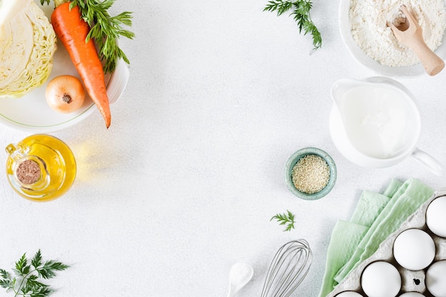 Ingrédients pour le chou et la tarte aux carottes chou carottes oeufs farine lait beurre épices sur fond blanc