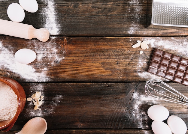 Ingrédients pour la cuisson du gâteau avec un rouleau à pâtisserie; moustache et cuillère sur la table