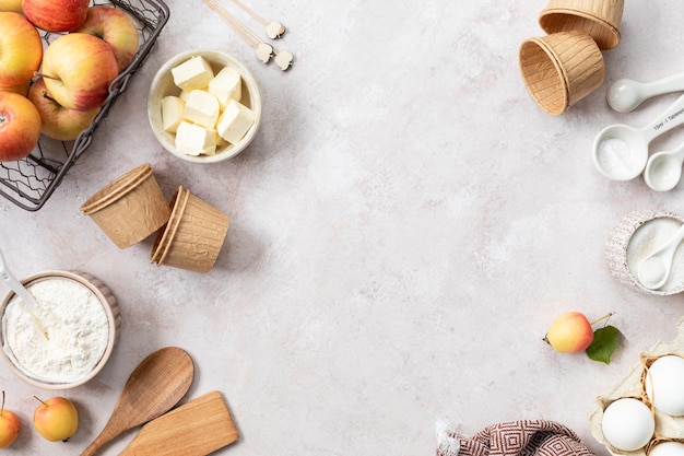 Photo gratuite ingrédients pour muffins cupcake aux pommes sucrées farine de beurre de sucre œufs de cannelle au miel sur fond clair en pierre vue du dessus