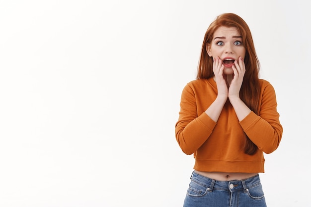 Inquiet jeune étudiante rousse troublée ne sait pas quoi faire, debout perplexe a eu des ennuis, voiture de petit ami écrasée, bouche bée et semblant peu sûre à l'avant, paniqué