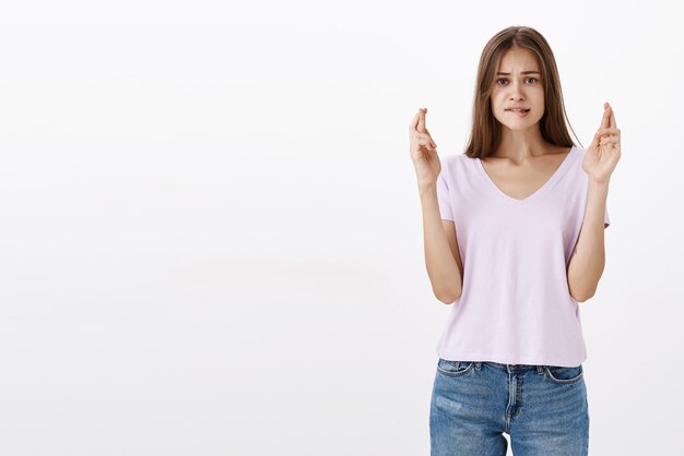 Inquiète, jolie brune espérant avoir réussi les examens pour entrer à l'université, elle rêve de se mordre la lèvre inférieure et de froncer les sourcils en regardant les doigts croisés intenses pour avoir de la chance tout en faisant un vœu