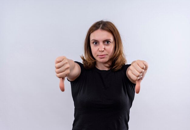 Insatisfait jeune femme décontractée montrant les pouces vers le bas sur un mur blanc isolé avec copie espace