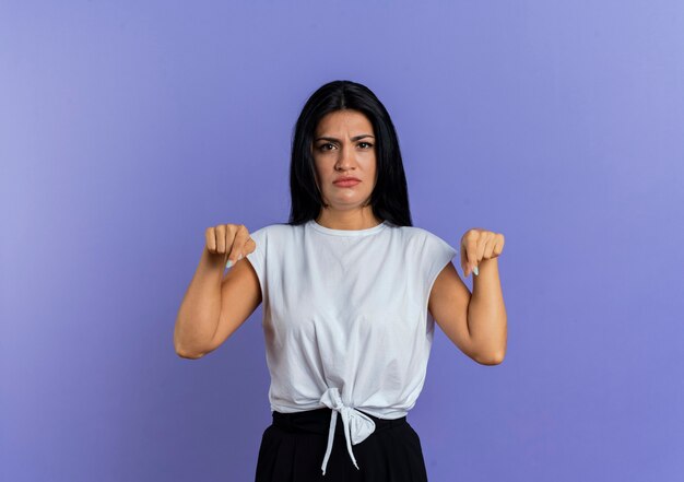 Insatisfait jeune fille caucasienne pointe vers le bas avec deux mains