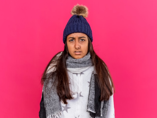 Photo gratuite insatisfait jeune fille malade portant chapeau d'hiver avec écharpe isolé sur fond rose