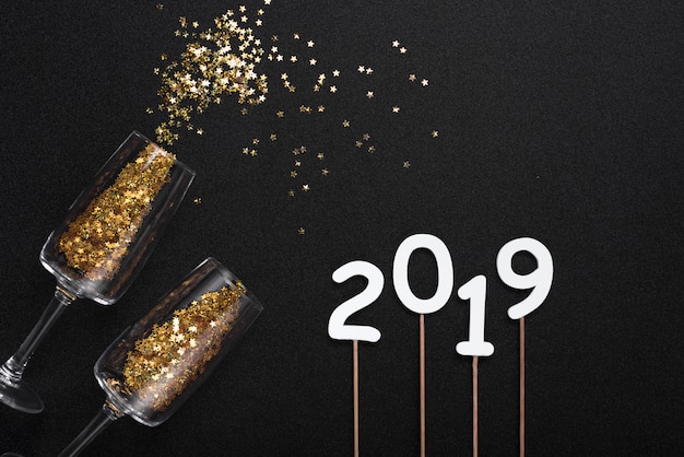 Inscription 2019 avec des paillettes dispersées dans des verres