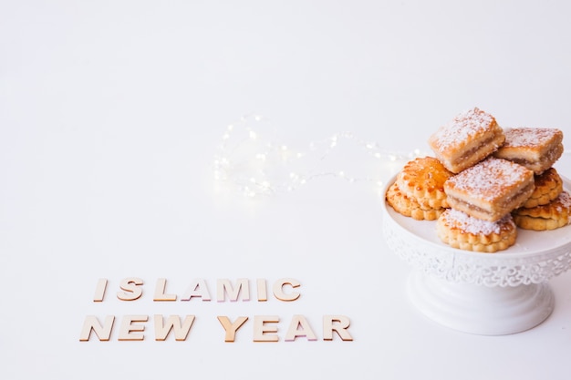 Photo gratuite inscription du nouvel an islamique et biscuits