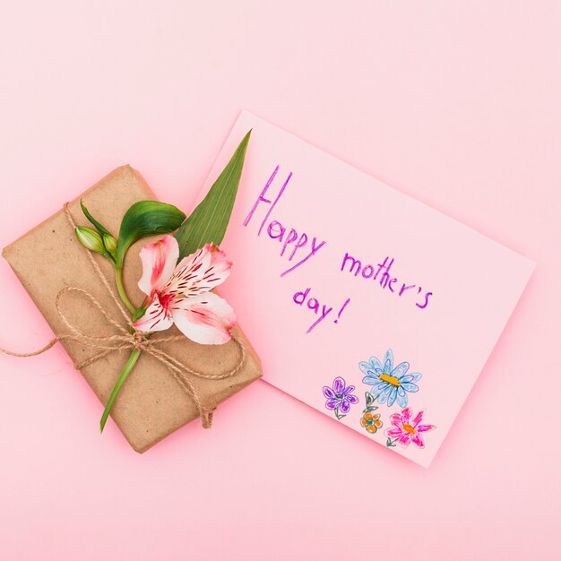Inscription heureuse fête des mères avec fleur et cadeau