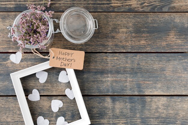 Inscription heureuse fête des mères avec des fleurs en boîte et cadre