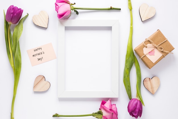 Inscription heureuse fête des mères avec des fleurs et un cadre