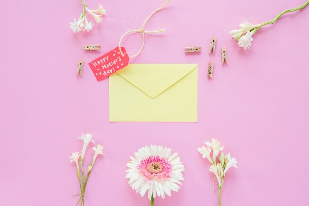 Inscription heureuse fête des mères avec des fleurs et enveloppe