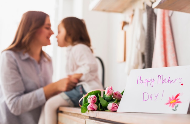 Photo gratuite inscription heureuse fête des mères près de mère et fille