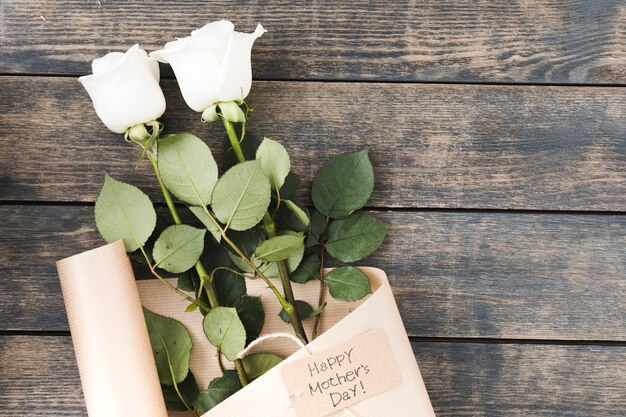 Inscription heureuse fête des mères avec des roses sur la table