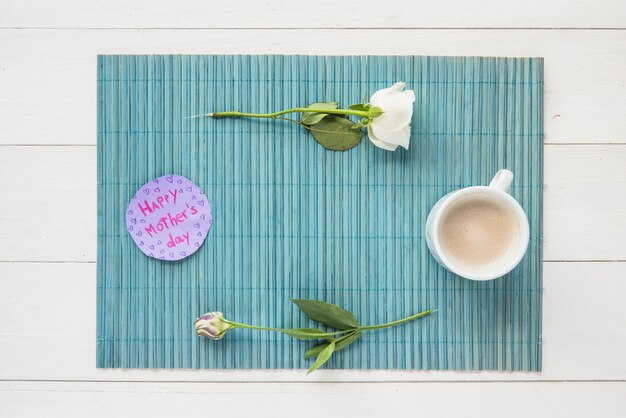 Inscription heureuse fête des mères avec des roses et une tasse de café