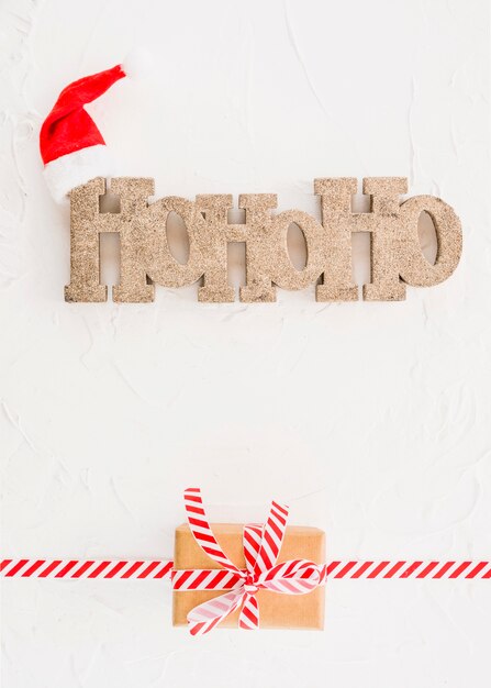 Inscription Ho Ho Ho près du chapeau de Noël et de la boîte à cadeaux