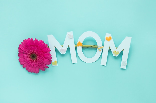 Inscription de maman avec fleur de gerbera sur table