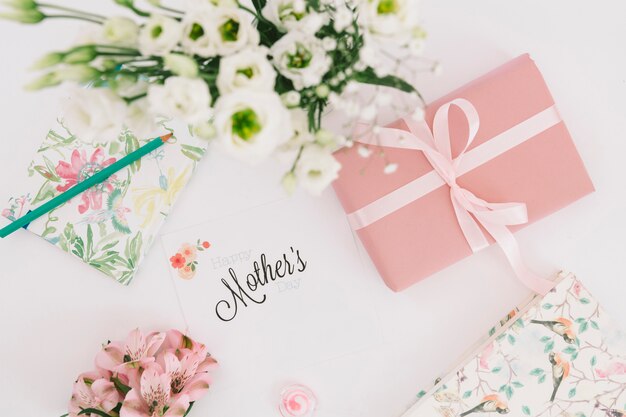 Inscription de mères avec des fleurs et une boîte cadeau